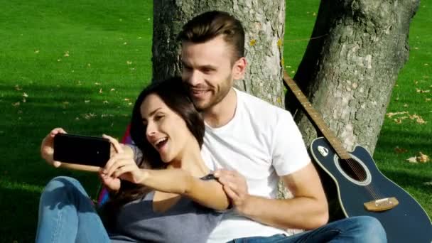 Casal Feliz Tirando Uma Foto Mesmos Com Smartphone Gramado Verde — Vídeo de Stock