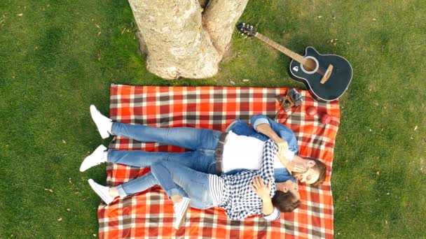 Ett Lyckligt Par Ligger Gräsmattan Och Åtnjuter Romantik Ovanifrån — Stockvideo