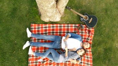 Bir ağacın altında yalan ve müzik mutlu çift. Üstten görünüm.