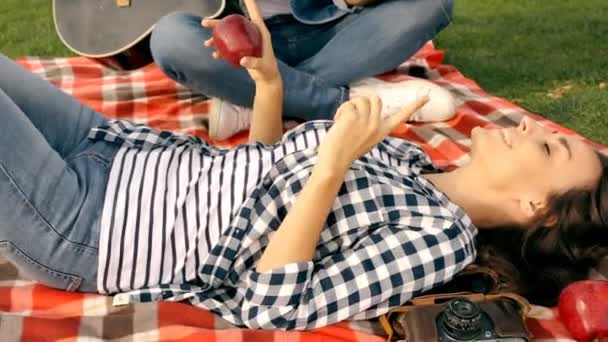 緑の芝生に良い時間を過ごして恋幸せなカップル 男はギターを弾く — ストック動画
