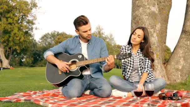 Feliz Casal Apaixonado Divertindo Gramado Verde Tipo Toca Guitarra — Vídeo de Stock