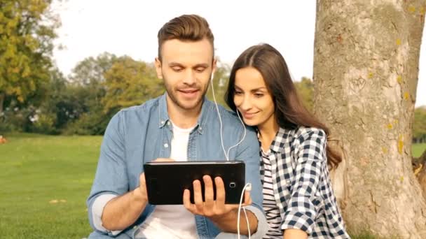 Couple Heureux Écoutant Musique Regardant Une Vidéo Dans Parc — Video