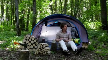 Backpacker bir defterde açık havada notlar alır. Doğada kamp.