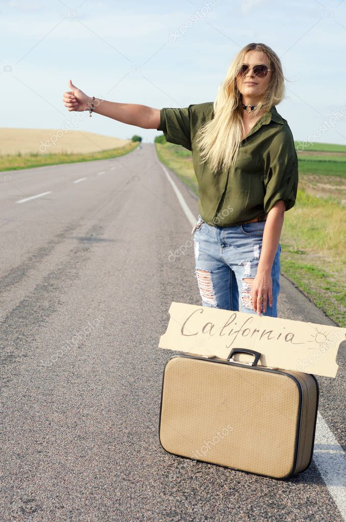 Beautiful Girl Hitchhiking On The Road Traveling.