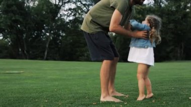 Baba küçük sevimli kızıyla oynuyor. Parkta açık hava.