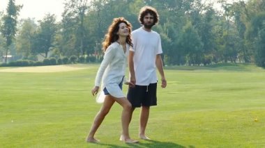Mutlu çift yürüyüş ve parkta açık havada eğlenmek. Yavaş çekim.
