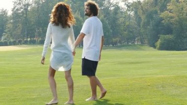 Mutlu çift yürüyüş ve parkta açık havada eğlenmek. Yavaş çekim.