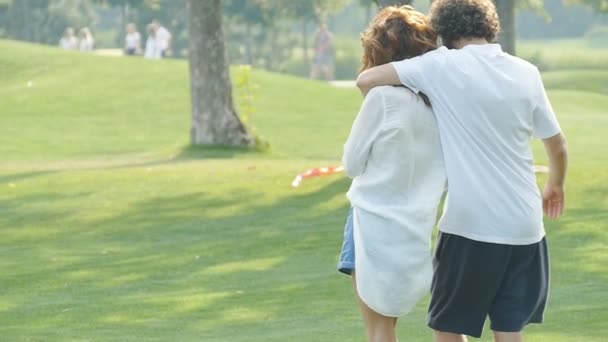 행복한 부부는 공원에서 산책하고 야외에서 즐거운 시간을 보내고 있습니다 슬로우 — 비디오