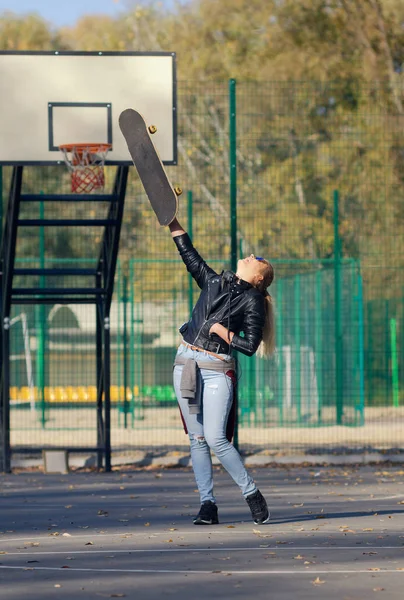 Hipster meisje poseren met een skateboard. — Stockfoto