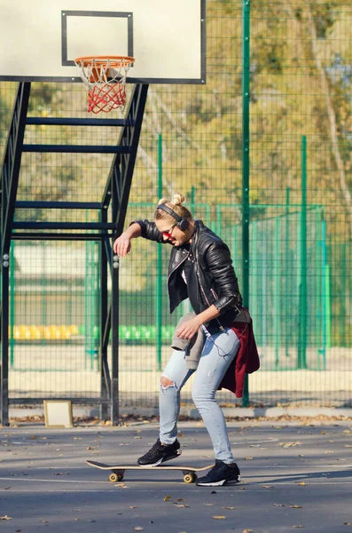 Hipster meisje poseren met een skateboard. — Stockfoto
