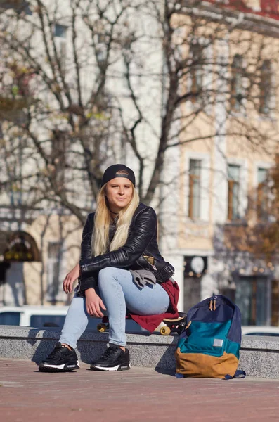 Mädchen lächelt glücklich, sitzt auf Skateboard. — Stockfoto