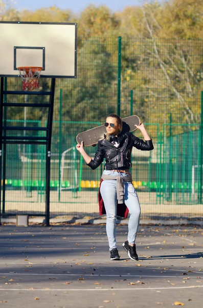 Hipster chica posando con un monopatín . —  Fotos de Stock