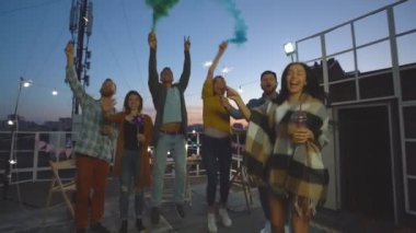 Arkadaşlar sis bombaları ve kıvılcımsal bir grup ve gece çatıda parti keyfini çıkarın.