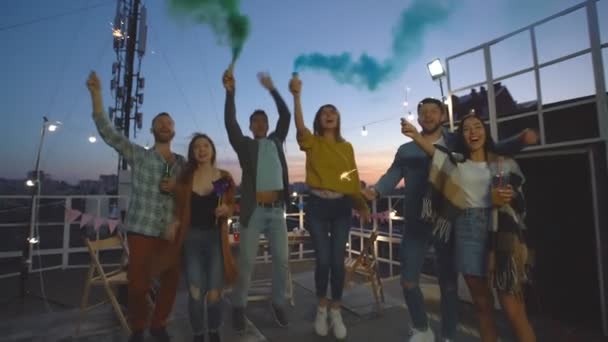 Grupo Amigos Acenando Bombas Fumaça Faíscas Desfrutar Festa Telhado Noite — Vídeo de Stock