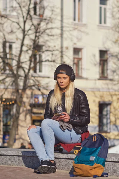 Mädchen lächelt glücklich, sitzt auf Skateboard. — Stockfoto