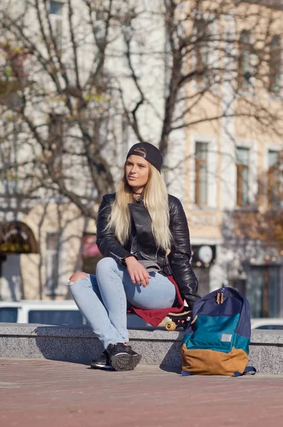 Mädchen lächelt glücklich, sitzt auf Skateboard. — Stockfoto