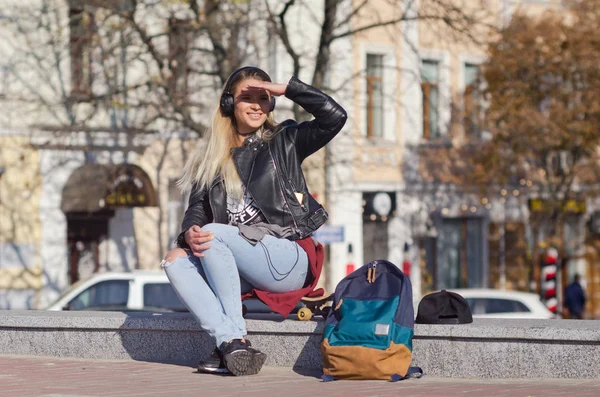 Senhora menina sorrisos felizes, senta-se skate . — Fotografia de Stock