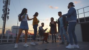 Çatı gece partisi, bir grup arkadaş dans ediyor ve eğleniyor. Yavaş çekim.