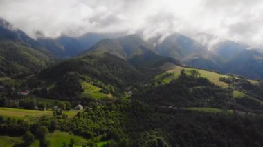 Bulutların arasındaki güzel dağların üzerinde uçan drone.