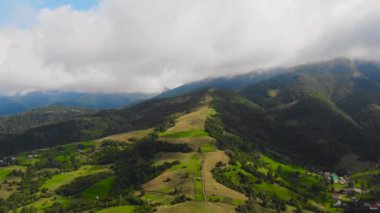 Bulutların arasındaki güzel dağların üzerinde uçan drone.