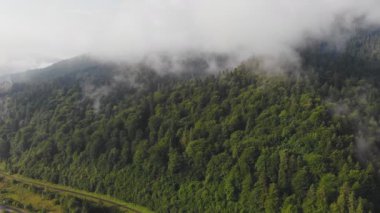 Bulutların arasındaki güzel dağların üzerinde uçan drone.
