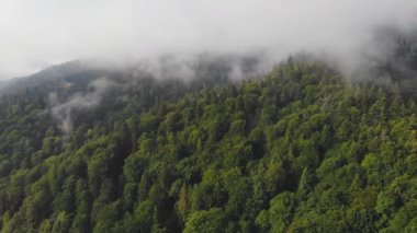 Bulutların arasındaki güzel dağların üzerinde uçan drone.