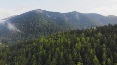 Bulutların arasındaki güzel dağların üzerinde uçan drone.