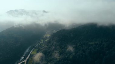 Bulutların arasındaki güzel dağların üzerinde uçan drone.