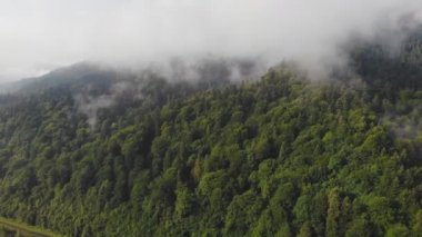 Bulutların arasındaki güzel dağların üzerinde uçan drone.