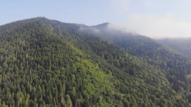 Bulutların arasındaki güzel dağların üzerinde uçan drone.