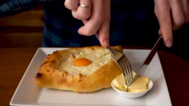 Bir adam Georgia'da bir kafede Adzhar Khachapuri yemeye hazırlanıyor. Cilt:1