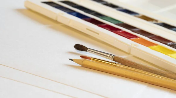 kalem ler ve fırçalar suluboya yan görünüm arka planda beyaz kağıt üzerinde yakın çekim