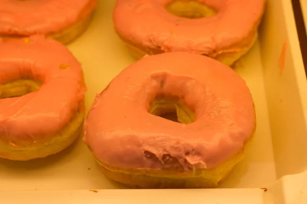 Donat di toko supermarket, di bawah bohlam lampu kuning — Stok Foto