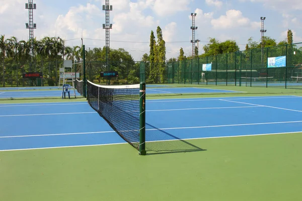 Теннисный корт на открытом воздухе с сеткой в дневное время — стоковое фото