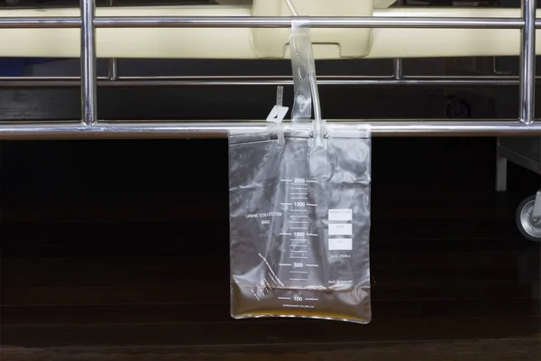 plastic urine collection bag hang under patient bed in hospital