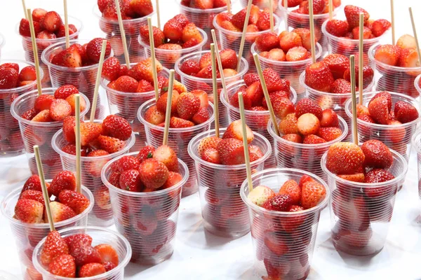 Frische Erdbeeren im Plastikbecher am Marktstand. — Stockfoto