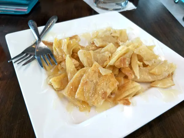 Hint gıda roti masada beyaz bir tabakta şekerli yoğunlaştırılmış süt ile.