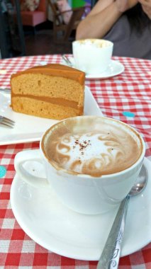 Kırmızı ve beyaz Gingham ekose kumaş masa üzerine beyaz kahve..