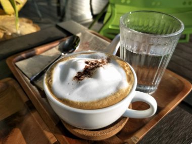 Beyaz fincan üzerinde Sabah bulanık Kahve latte, ahşap masada bir kahve dükkanı kafe.