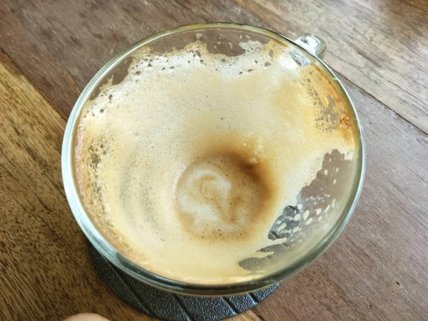 Mancha de café em um vidro transparente em um piso de madeira . — Fotografia de Stock