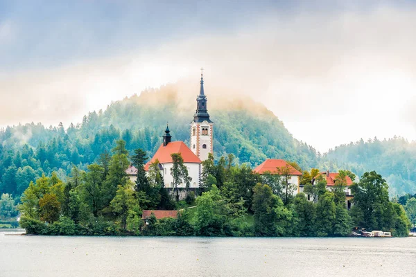 Vue de l'église de l'Assomption de Sainte-Marie dans la brume matinale sur l'île de Bled Lake en Slovénie — Photo