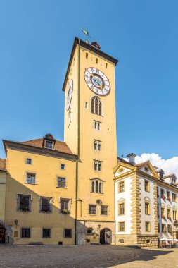 REGENSBURG, GERMANY - 10 AĞUSTOS 2020 - Regensburg sokaklarındaki saat kulesi. Regensburg, Almanya 'da Tuna, Naab ve Regen nehirlerinin birleştiği yerde yer alan bir şehirdir..