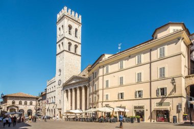 ASSISI, İtalya - 3 Eylül 2020 - Assisi 'deki Santa Maria sopra Minerva Kilisesi ile Comune aquare' de manzara. Assisi, İtalya 'nın Umbria bölgesinde, Perugia iline bağlı bir şehirdir..