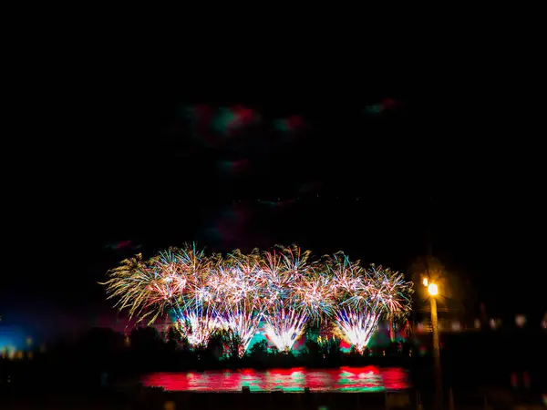 Fogos de artifício coloridos com múltiplas explosões contra o céu escuro — Fotografia de Stock