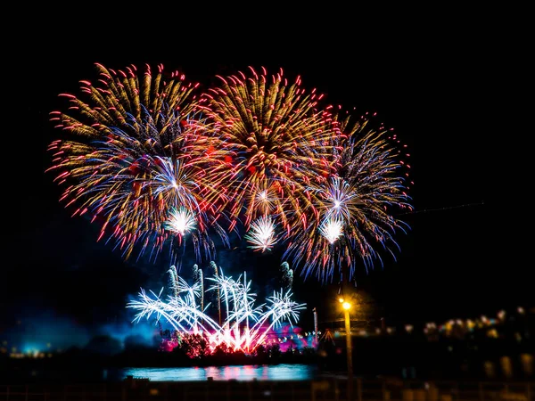 Fogos de artifício coloridos com múltiplas explosões contra o céu escuro — Fotografia de Stock