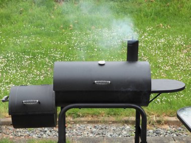 Backyard barbequing üzerinde bir kömür sigara içen