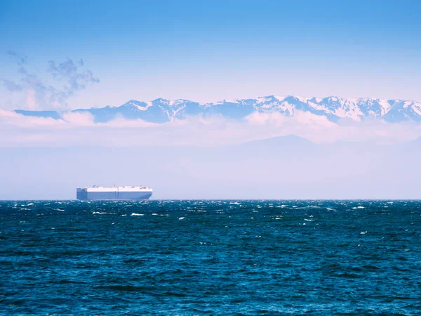 Gran buque de carga en el Océano Pacífico contra la montaña — Foto de Stock