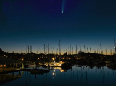 Kuyruklu yıldız gökyüzünde Sidney, BC, Vancouver Adası 'ndaki limanda demirlemiş yatların üzerinde.