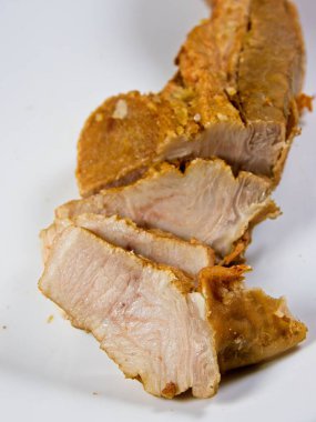 Dilimlenmiş domuz göbeği ve beyaz tabakta mavi bıçak.