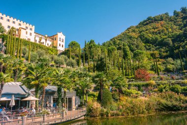 Hotel complex on lake shore, green trees background 